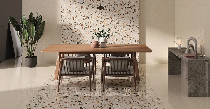 Galerie-Bild 3: Ein Esszimmer mit Holztisch und Stühlen vor einem Wanddetail aus weißen Terrazzofliesen.