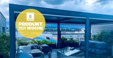 Ein überdachtes Wohnzimmer im Freien ist mit Möbeln und Pflanzen ausgestattet. Im Hintergrund erstrecken sich Gebäude und ein bewölkter Himmel. Text auf gelbem Kreis: 8 PRODUKT DER WOCHE.