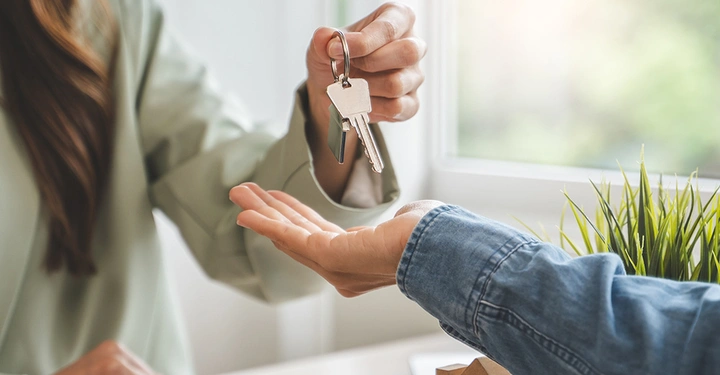 Die neue Hauseigentümerin nimmt die Schlüssel entgegen, nachdem alle vertraglichen Details, inklusive der gesetzlich geregelten Maklerprovision, erfüllt sind.