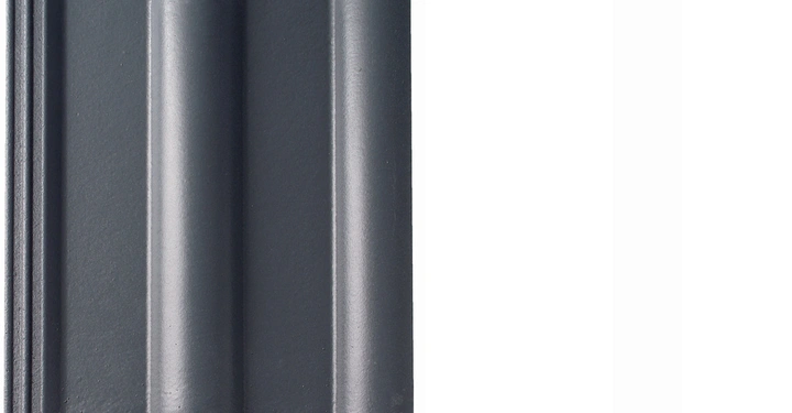 Dunkle rechteckige Dachziegel mit gewellter Oberflächenstruktur ruhend auf einem weißen Hintergrund