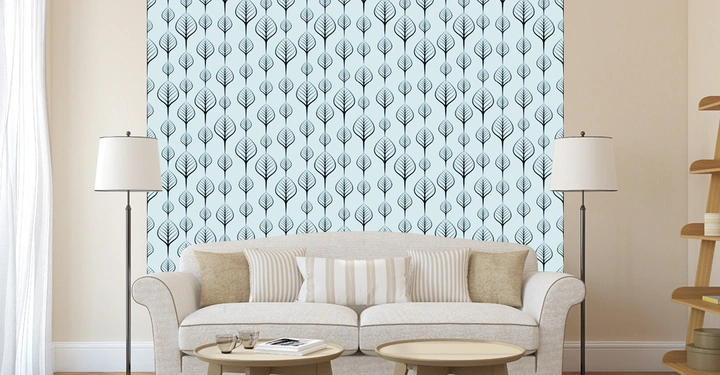 Sofa mit Kissen stehend vor einer Wand mit blauem, blattgemustertem Tapetenmuster im Wohnzimmer ergänzt durch zwei Stehlampen und ein runder Couchtisch auf einem beigen Teppich.