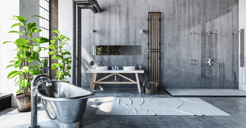 Freistehende Badewanne aus Metall neben Wachspflanzen links, zwei Waschbecken mit Spiegel auf Holzuntergestell in der Mitte, moderne Dusche mit Glaswand rechts in einem modernen, betonfarbenen Bad.