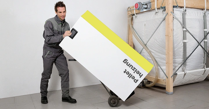 Galerie-Bild 1: Mann transportiert Kiste mit Pellets