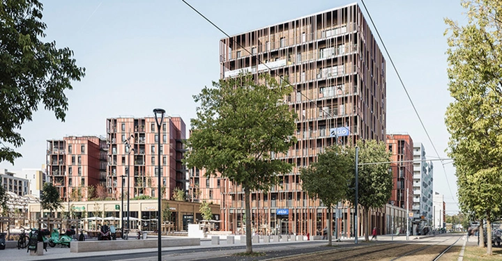 riesiger Mehrgeschoßer aus Holz mitten in der Stadt Toulouse, Bäume und Grünflächen wechseln sich mit Straße und Gehwegen ab. freundliches Ambiente