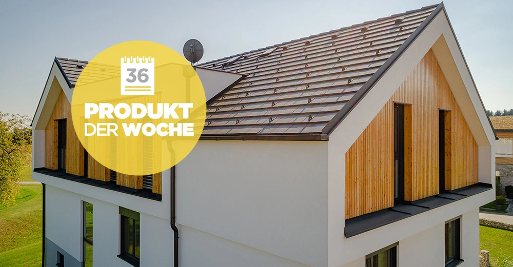 Modernes zweistöckiges Gebäude mit Satteldach und Holzverkleidung Sonnenschein gelber Kreis mit Text 36 PRODUKT DER WOCHE darum herum Garten und Bäume im Hintergrund