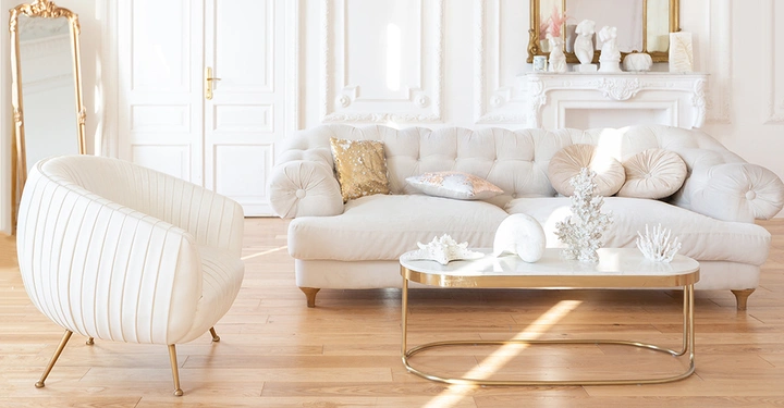 Galerie-Bild 5: Ein lichtdurchflutetes Wohnzimmer mit hellen Möbeln und goldenen Akzenten.