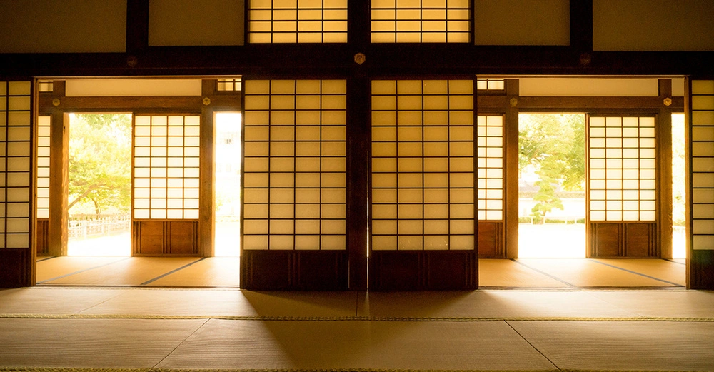 riesiger Raum mit schönen Shoji-Papierwänden, halb geöffnet und mit Sonne, die von draußen hereinscheint. Angenehme, heimelige Stimmung