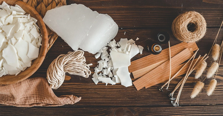 Holztisch mit allen Utensilien für die Herstellung von Duftkerzen. 