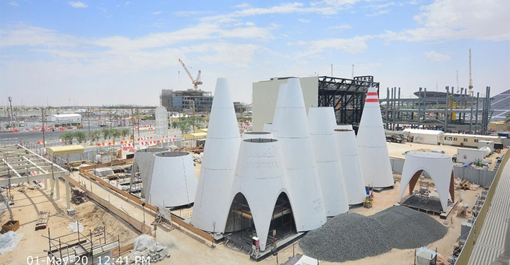 Galerie-Bild 5: Kegelförmige Strukturen stehen nebeneinander auf einer Baustelle; Baukräne und Gebäude im Hintergrund. Text auf Strukturen Austria. Aufgenommen am 1. Mai 20 um 12 41 PM