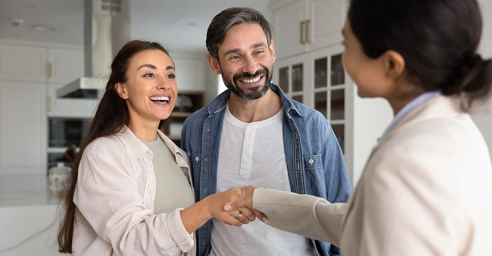 Privater Vermieterin übergibt Wohnung an glückliche Mieter. Handschlag bei erfolgreicher Wohnungsvermietung, symbolisch für Vertrauen und Zufriedenheit beim privaten Vermieten.