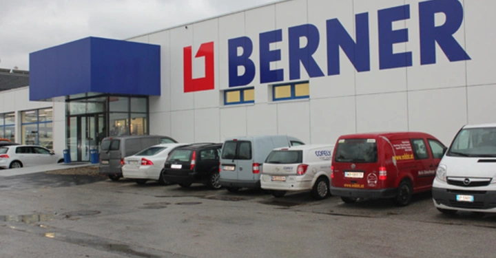 Galerie-Bild 7: Ein großes Gebäude mit dem Schriftzug BERNER an der Fassade geparkte Autos davor wolkiger Himmel