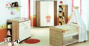 Babybett mit Baldachin steht in einem hellen Kinderzimmer mit Schränken Spielzeug und Wickeltisch auf einem hellen Teppich der von bunten Vorhängen umgeben ist.