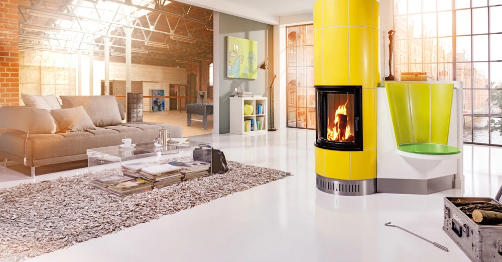 Gelber Kaminofen brennt im modernen Wohnzimmer neben einem grauen Sofa und einem Glastisch vor großen Fenstern mit industriellem Design; links ein Industrie-Loft im Hintergrund.