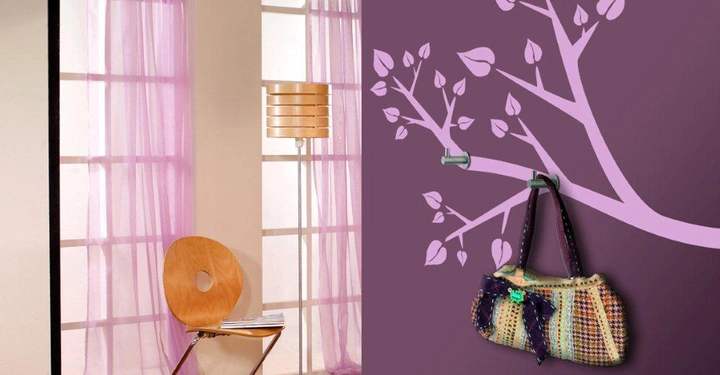 Galerie-Bild 4: Ein heller Raum mit zwei großen Fenstern und lila Vorhängen. Ein Holzstuhl steht vor einem Bücherstapel. Eine lila Wand mit einem Baumzweigbild hat eine bunte Tasche an einem Haken. © Rauch
