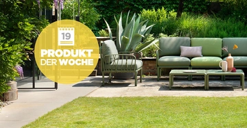 Grüne Couchgarnitur steht neben einem Tisch mit Deko in einem Garten mit viel Grün. Gelber Kreis mit dem Text 19 Produkt der Woche auf der linken Seite.