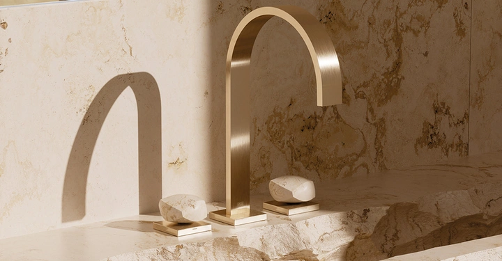 goldene Badarmatur gebürstet an grob geschlagenem Steinwaschbecken von Dornbracht. 