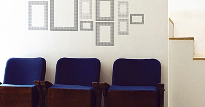 Galerie-Bild 16: Drei blaue Kinosessel stehen nebeneinander an einer weißen Wand mit leeren Bilderrahmen darüber in einem Raum mit Holzboden. Eine Treppe befindet sich rechts daneben.