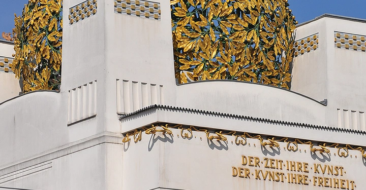 Detailansicht der Wiener Secession mit goldener Lorbeerkuppel und dem Schriftzug "Der Zeit ihre Kunst. Der Kunst ihre Freiheit.". Symbol des Jugendstils in Wien.