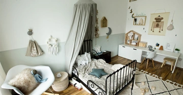 Schwarzes Kinderbett mit grauem Baldachin steht in einem liebevoll dekorierten Zimmer mit weißen und holzfarbenen Möbeln Wandkunst und Spielsachen Ein Buch trägt den Titel The Book with No Pictures