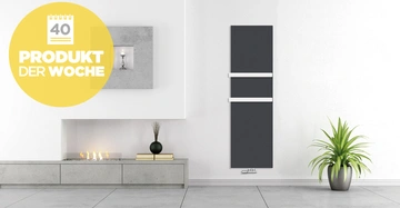 Ein grauer Heizkörper hängt an einer weißen Wand neben einem grünen Pflanzentopf im modernen Wohnraum mit einem kleinen Feuer. Text: 40 PRODUKT DER WOCHE.