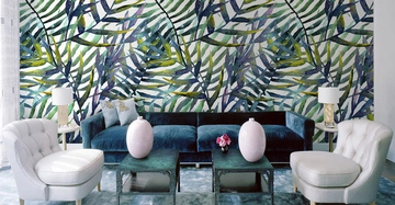 Zwei weiße Sesseln und ein dunkelblaues Sofa stehen vor einer Wand mit buntem Blattmuster. Ein Couchtisch mit rosa Vase und Beistelltische mit Lampen sind ebenfalls im Wohnzimmer.