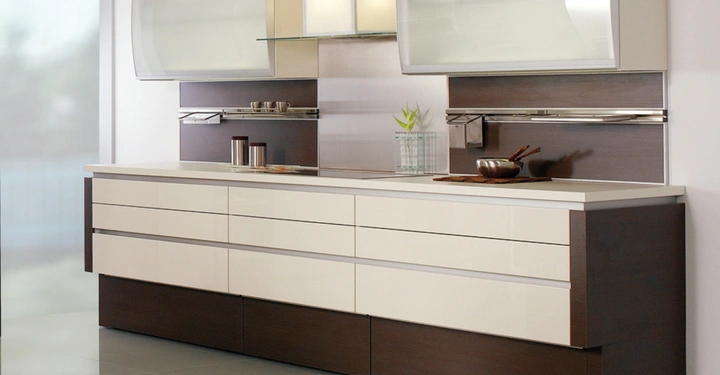 Galerie-Bild 1: Der Küchenschrank steht still in einer modernen Küche mit großen Schubladen und Schränken in weiß und dunkelbraun vor einer glatten Wand und glänzendem Boden.