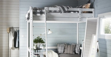 Hochbett mit kariertem Bettzeug steht über einem grauen Sofa mit gestreiften Kissen, in einem Raum mit blauen Holzwänden, einem Fenster, einem Spiegel und einer Kleiderstange.