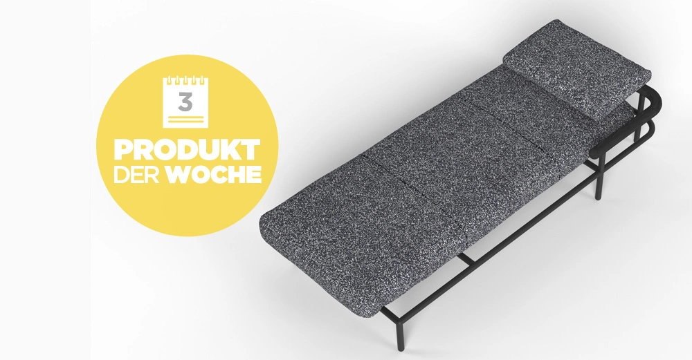 Eine graue Liege steht ruhig in einem minimalistischen Raum. Ein gelbes Rundschild zeigt: 3 PRODUKT DER WOCHE