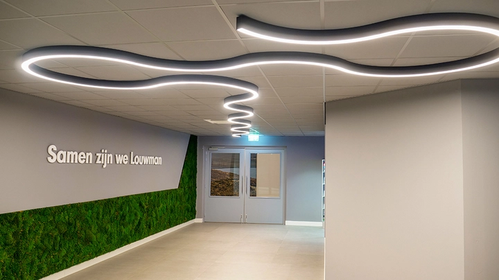 Galerie-Bild 1: Büroflur mit Green Wall links udn schlangenlinienförmiger Beleuchtung an der Decke.