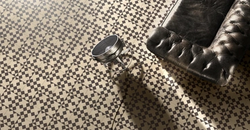 Sofa und Stehlampe liegen auf einem Boden mit geometrischen schwarz-weißen Mustern.