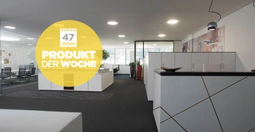 Gelber Kreis mit Text hängt über modernen Büro Cubicle Schreibtisch mit weißem Möbeln und schwarzen Teppiche Boden in einem hellen Büro mit Glastrennwände Text 47 PRODUKT DER WOCHE