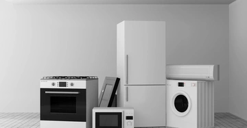 Mehrere Haushaltsgeräte wie Ofen Kühlschrank Mikrowelle Waschmaschine und Klimaanlage stehen in einem modernen leeren Raum auf einem Fliesenboden unter einer weißen Decke mit eingebauten Lichtern.