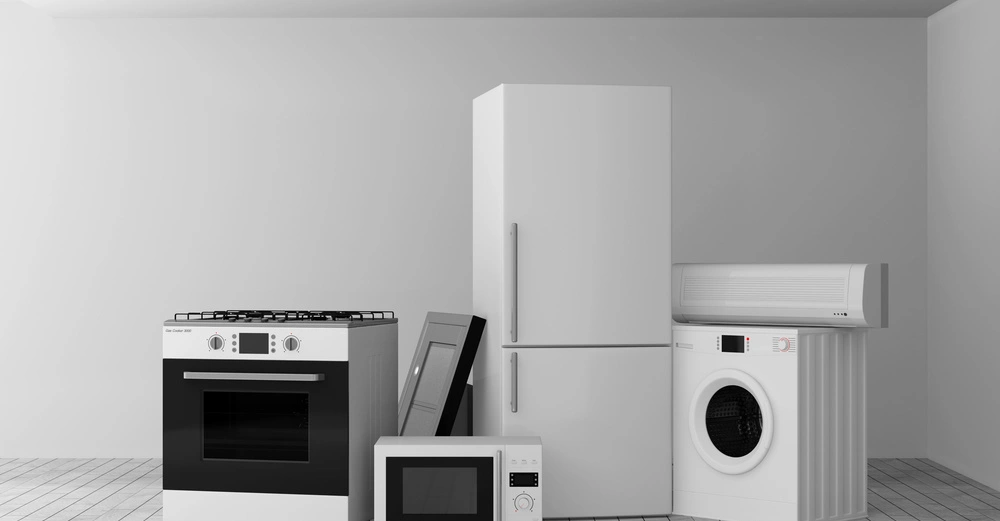 Mehrere Haushaltsgeräte wie Ofen Kühlschrank Mikrowelle Waschmaschine und Klimaanlage stehen in einem modernen leeren Raum auf einem Fliesenboden unter einer weißen Decke mit eingebauten Lichtern.