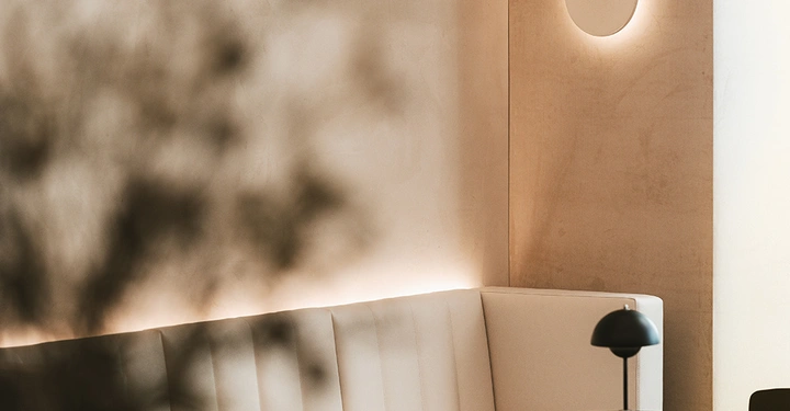 Eine Couch vor einer PANDOMO Clay Kalk-Lehm-Putz Wand