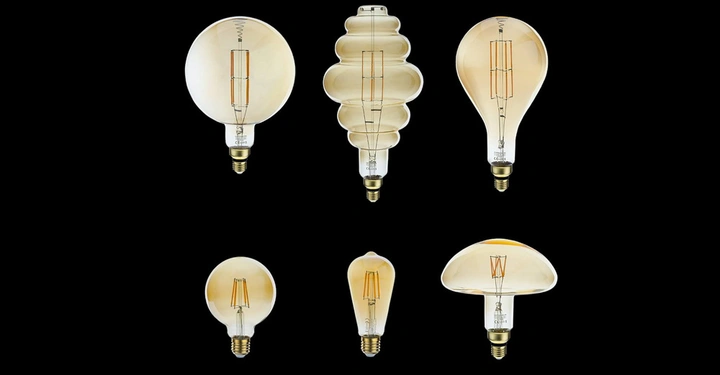 Sechs Glühbirnen verschiedene Formen und Größen stehend aufrecht ordnen sich in zwei Reihen in einer schwarzen Umgebung an keine Text.