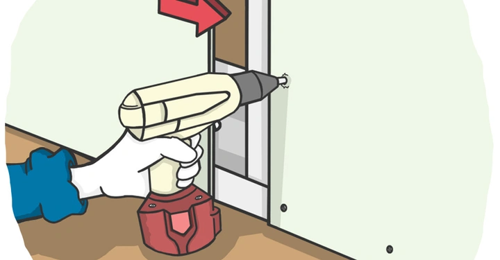 Bohrmaschine bohrt in eine Wand; rote Pfeil zeigt die Position des Bohrlochs; hinten ist ein unvollständiger Rahmen sichtbar; die Umgebung ist ein heller Raum mit Holzboden.