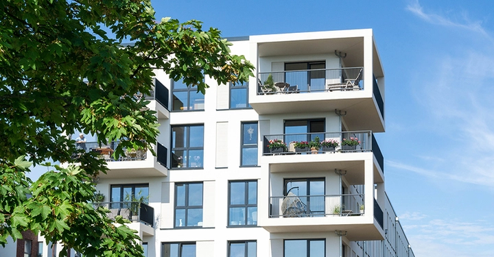 Modernes weißes Wohnhäuser in der Stadt mit Baum im Vordergrund