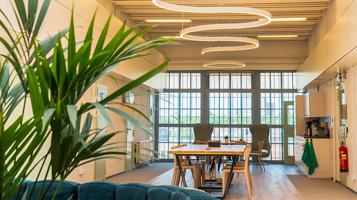 Galerie-Bild 1: helle moderne Büroküche mit Esstisch und Stühlen, Fensterfront und moderner Beleuchtung.