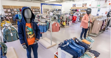 Kleidungsgeschäft Kinderabteilung Ansicht von Kleiderpuppen und gestapelter Verkaufsware