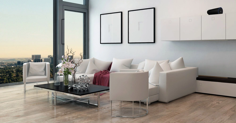 Ein modernes Wohnzimmer zeigt weiße Möbel wie Sofas und Stühle, einen niedrigen schwarzen Tisch mit Blumen und Dekoration, große Fenster, hellen Holzboden und zwei minimalistische Bilder an der Wand.