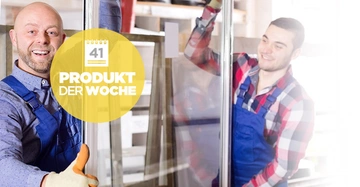 Zwei Männer halten eine Glasscheibe. Einer zeigt Daumen hoch. Beide tragen blaue Latzhosen. Im Hintergrund befinden sich Regale. Text: 41 Produkt der Woche