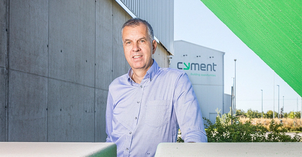 Geschäftsführer von cyment Austria steht vor Firmengebäude. Legerer Businesslook mit Hemd ohne Krawatte. 