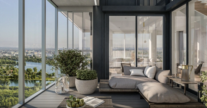 Ein Sofa steht auf einem Balkon, umgeben von Pflanzen und Gläsern, während durch die Glaswände eine Stadtlandschaft mit Fluss und Wald im Hintergrund sichtbar ist.
