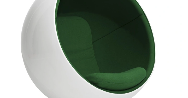 Weißer kugelförmiger Stuhl mit grünem Innenpolster steht auf einem runden Fuß in einem minimalistischen weißen Raum.