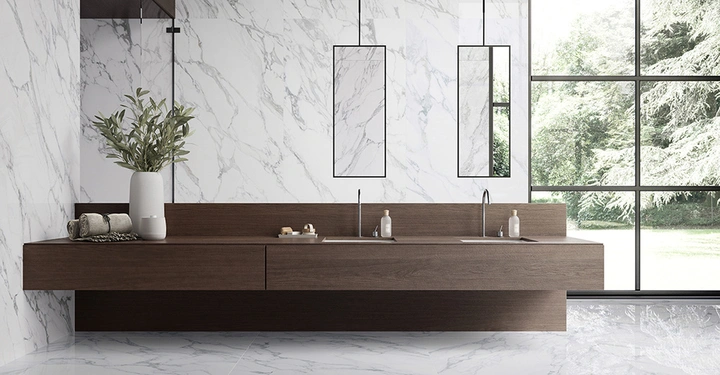 Galerie-Bild 5: Ein edler Waschtisch aus braunem Holz in einem Badezimmer aus großformatigen Fliesen im Marmorlook.