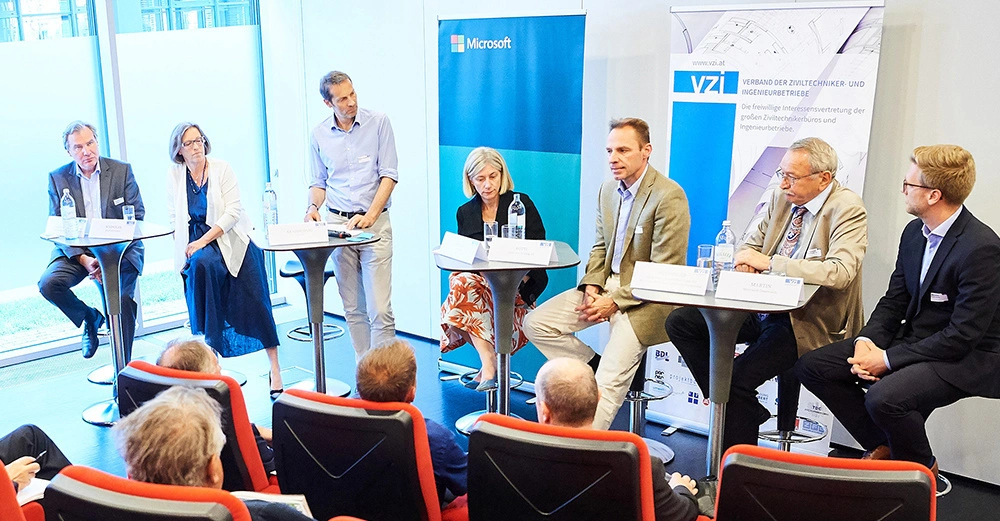 Personen diskutieren an einem Tisch in einem Konferenzraum Microsoft VZI