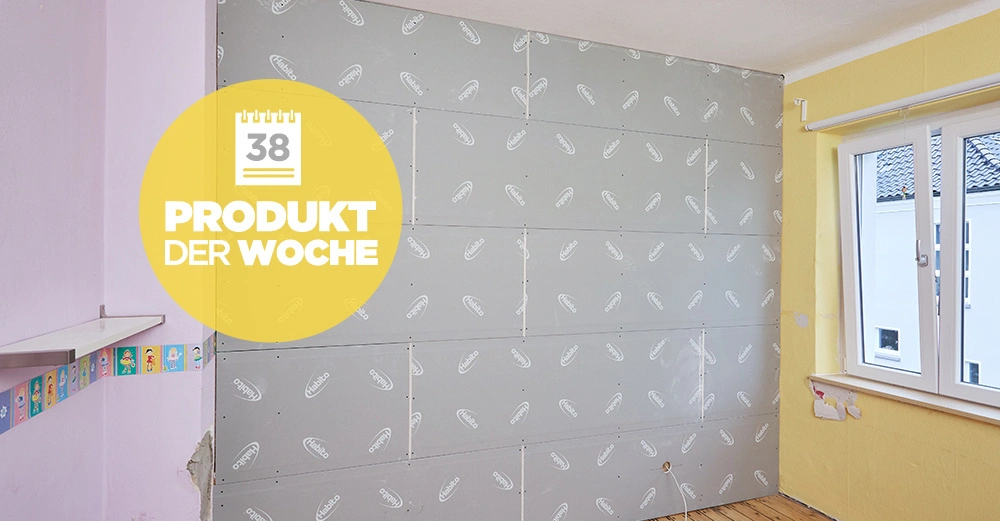 Eine Wandverkleidung bestehend aus Gipskartonplatten wird montiert in einem teilweise renovierten Raum mit bunten Wänden und einem Fenster auf der rechten Seite. Text: 38 PRODUKT DER WOCHE