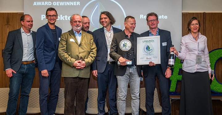 Vertreter des Unternehmens RENOWATE stehen gemeinsam mit dem Ehepaar Ghezzo auf der Bühne und präsentieren ihren Award. 