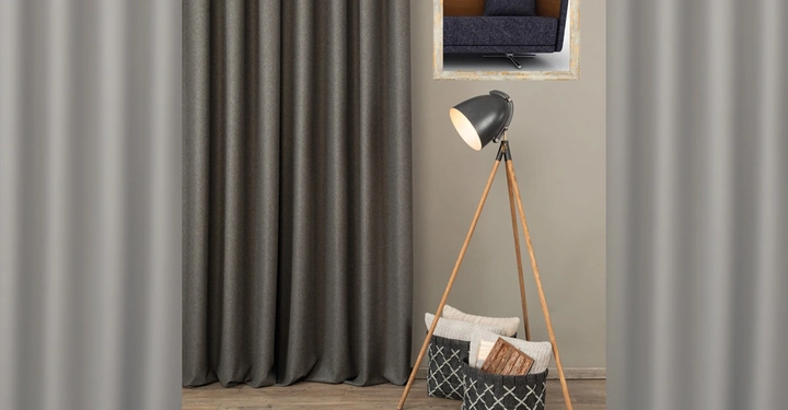 Galerie-Bild 9: Stehlampe auf einem Holzstativ steht neben zwei gefüllten Körben vor einem dunkelgrauen Vorhang. Ein gerahmtes Bild eines Sofas hängt an der grauen Wand darüber.