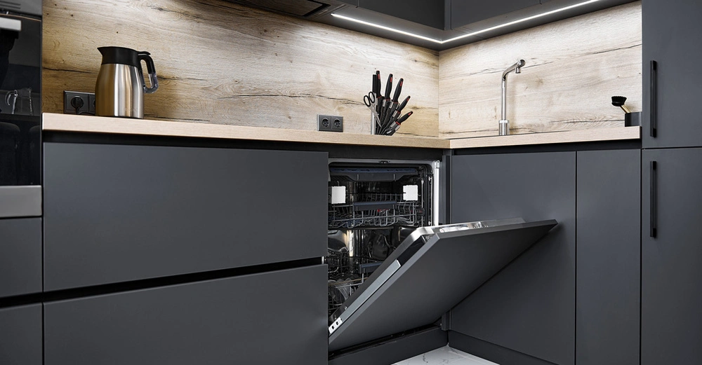 topmoderne schwarze Küche, Geschirrspüler-Tür halb heruntergeklappt. Messerblock, Wasserkocher in Edelstahl stehen auf indirekt beleuchteter Arbeitsplatte